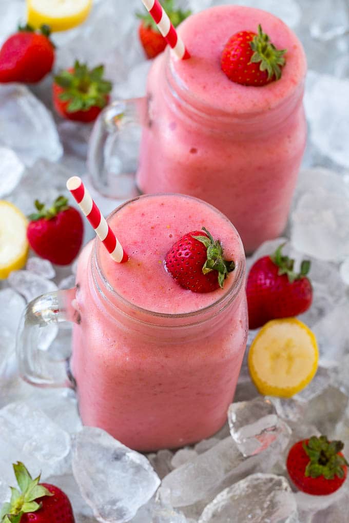 Strawberry banana smoothie jars on ice.