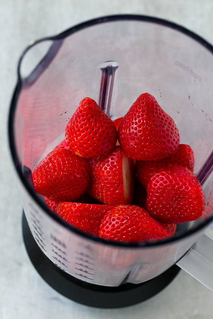 Strawberries and sugar in a blender.