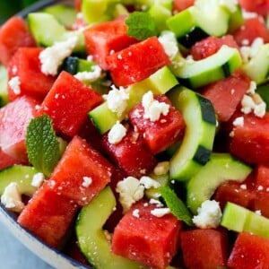 Watermelon salad with cucumbers, feta cheese and mint in a serving bowl.