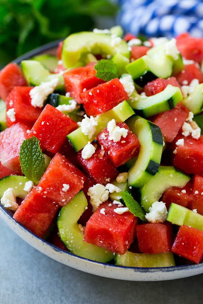 Watermelon salad with cucumbers, feta cheese and mint in a serving bowl.