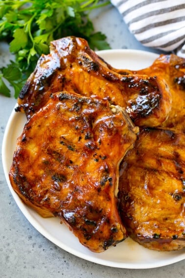 BBQ pork chops are bone in pork chops that have been grilled and topped with barbecue sauce.