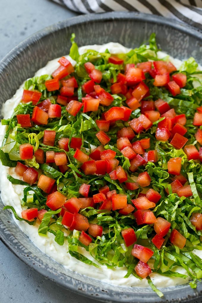 Lettuce and tomatoes on top of ranch dip.