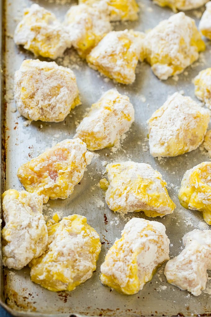 Chicken breast pieces coated in eggs and seasoned flour.