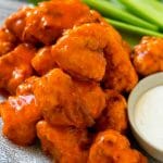 Buffalo chicken nuggets with ranch dressing and celery sticks.