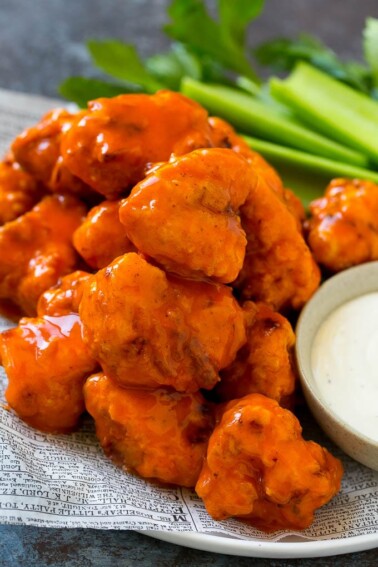 Buffalo chicken nuggets with ranch dressing and celery sticks.