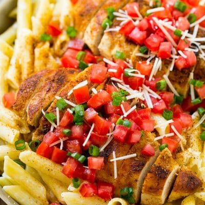 Cajun chicken pasta with grilled chicken breast, creamy penne pasta, tomatoes and green onions.