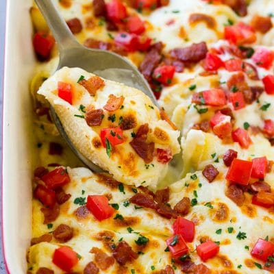 Chicken alfredo stuffed shells topped with bacon, tomatoes and parsley.