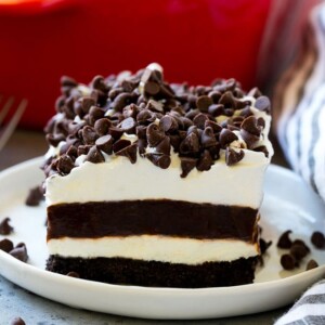 A slice of chocolate lasagna with layers of cookie crust, cheesecake and chocolate pudding.