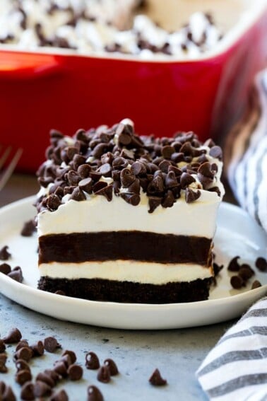 A slice of chocolate lasagna with layers of cookie crust, cheesecake and chocolate pudding.