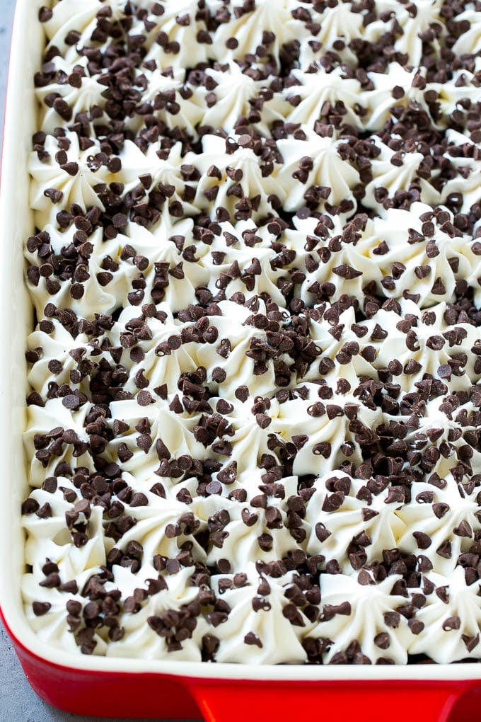 A pan of chocolate lasagna topped with whipped cream and miniature chocolate chips.