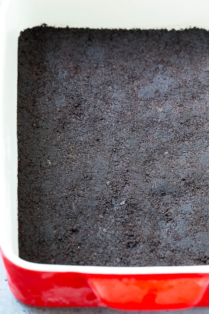 An oreo cookie crust in a rectangular baking dish.