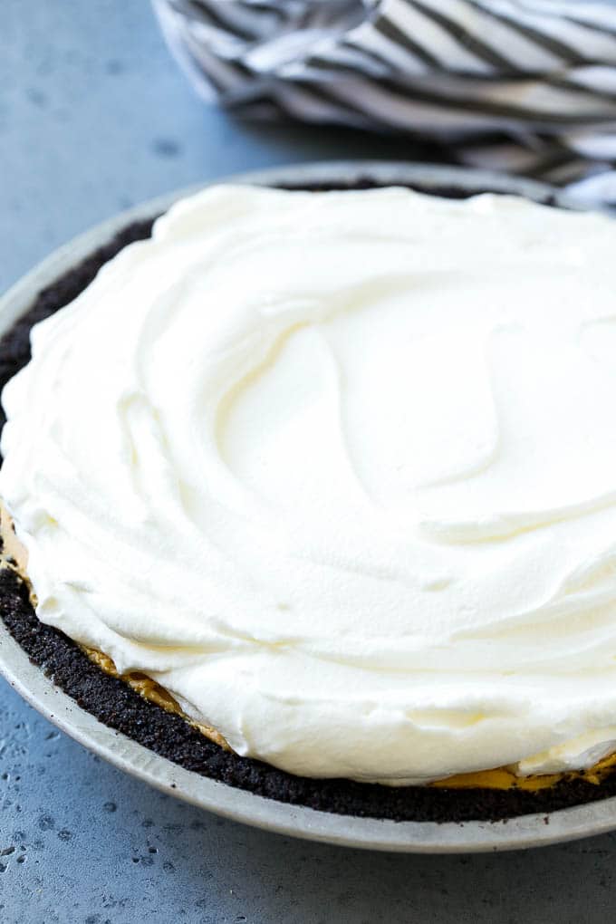 A chocolate peanut butter pie with a chocolate crust, peanut butter filling and whipped cream topping.