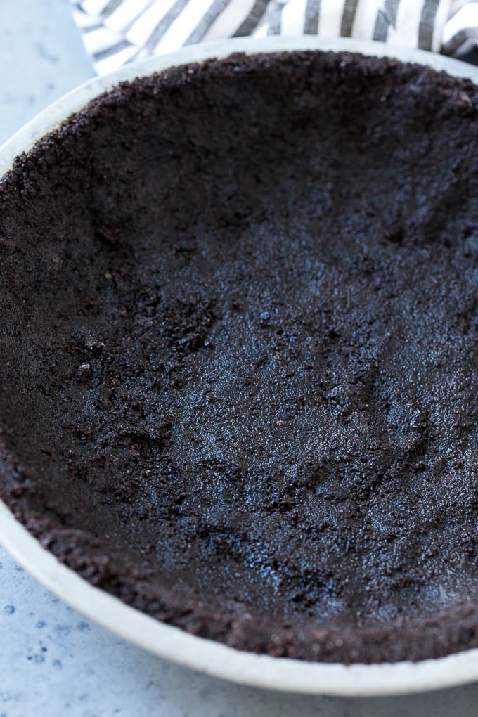 Chocolate cookie crust in a pie tin.