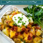 These grilled potatoes in foil are diced potatoes cooked in ranch butter, then topped with melted cheese, bacon, sour cream and chives.
