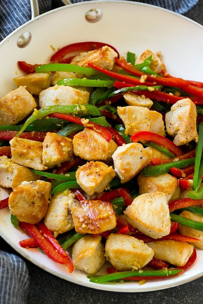 Chicken, bell peppers, garlic and ginger in a skillet.
