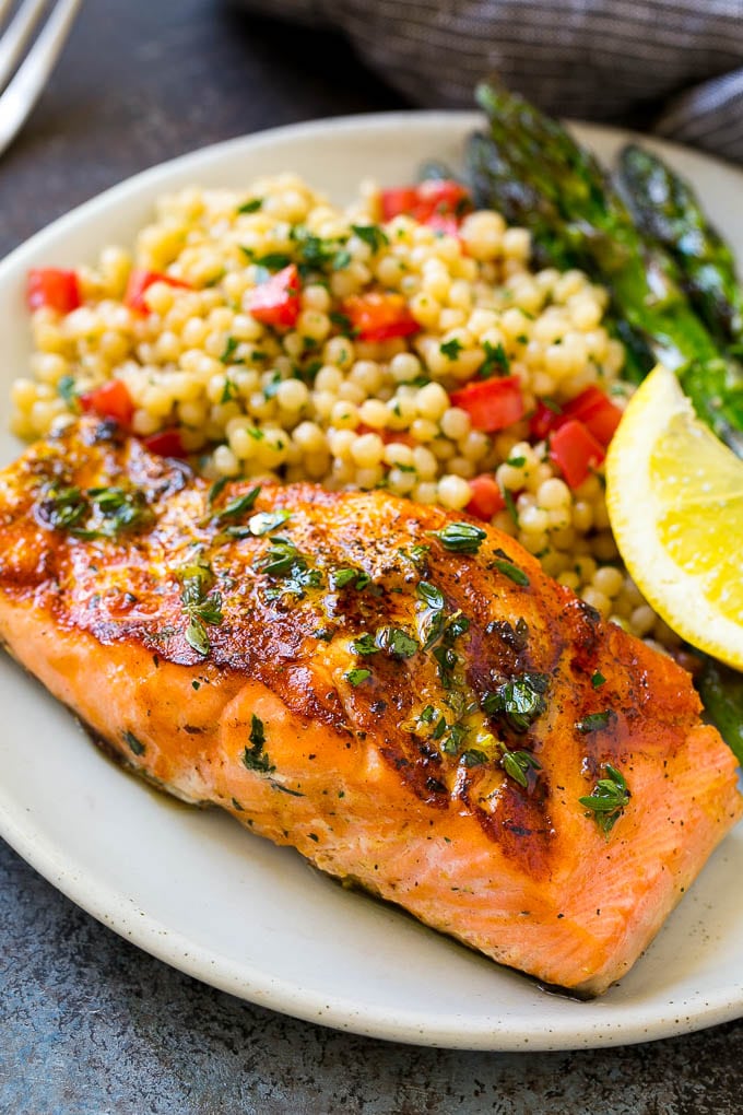 Marinated salmon served over couscous with asparagus on the side.