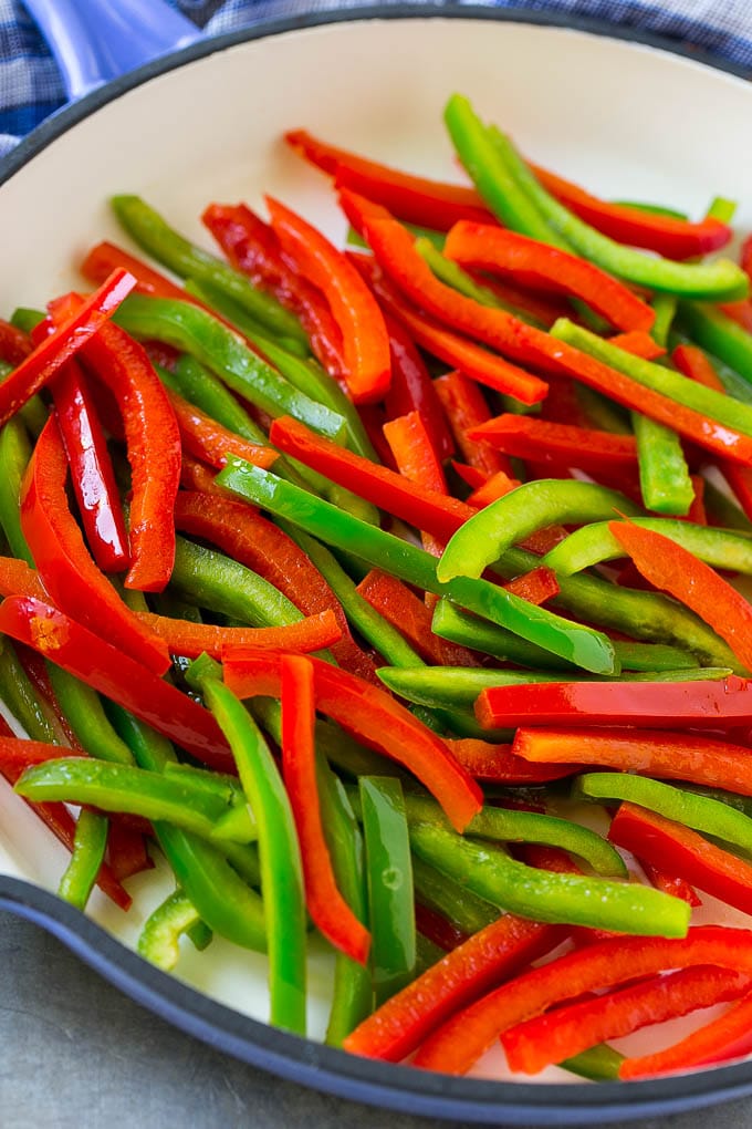 Cooked red and green bell peppers in a skillet.