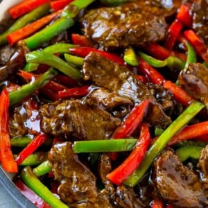 Pepper steak stir fry with thinly sliced steak and red and green bell peppers in a savory sauce.