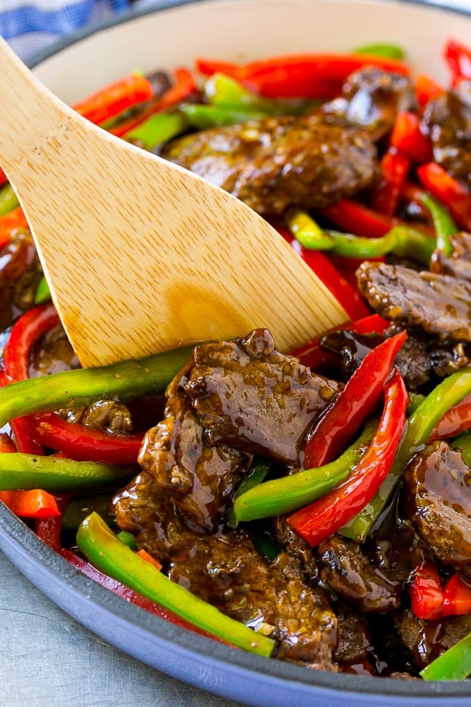 Pepper steak stir fry with a serving utensil in it.