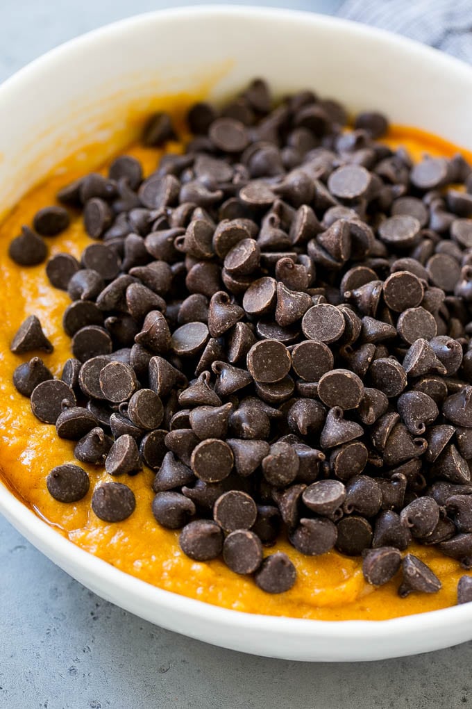 Pumpkin cookie batter with chocolate chips in a bowl.