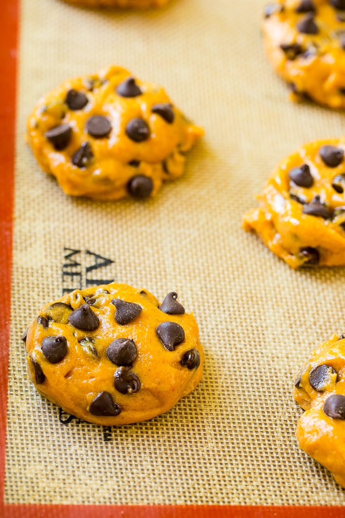 Dollops of pumpkin chocolate chip cookie dough on a baking sheet.