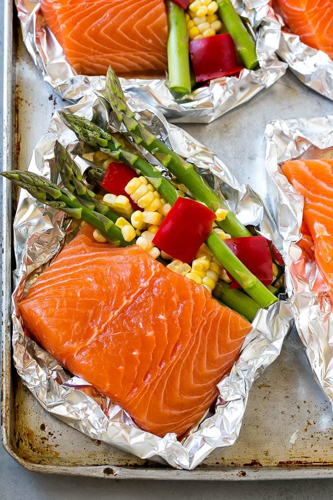 Raw salmon fillets with asparagus in foil.