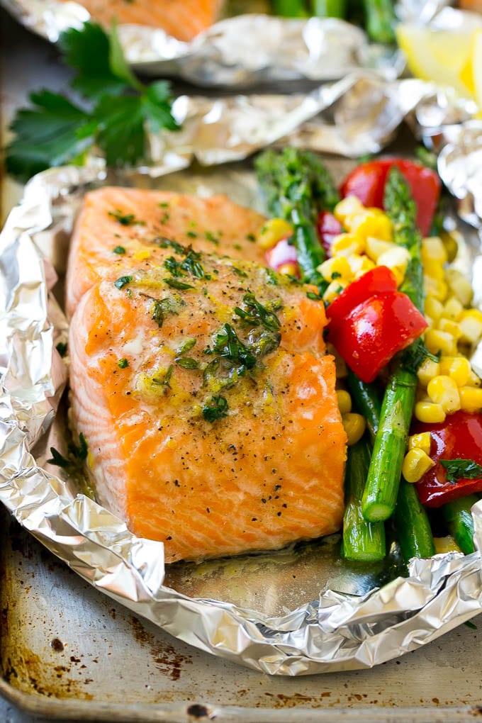 A salmon foil packet with asparagus, corn and red bell pepper.