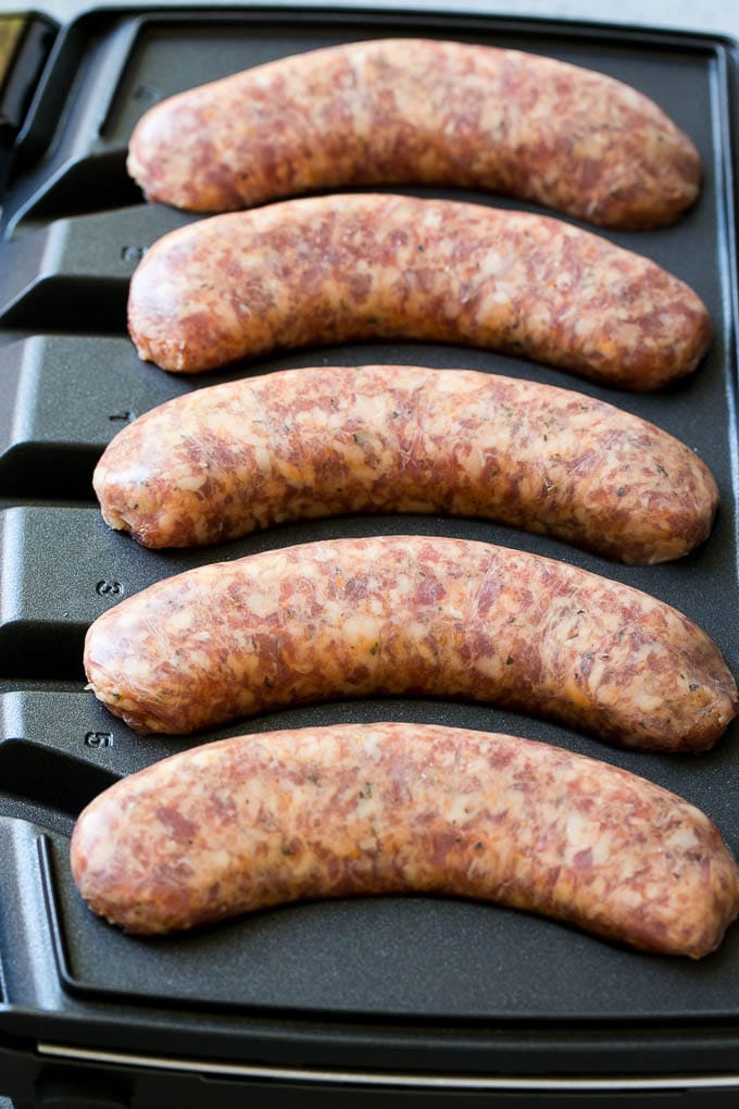 Sausages cooking in a sizzling sausage grill.