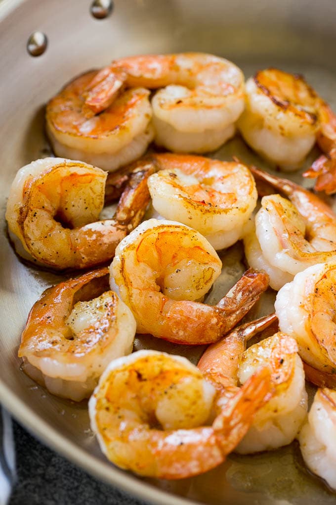 Seared shrimp in butter, in a skillet.