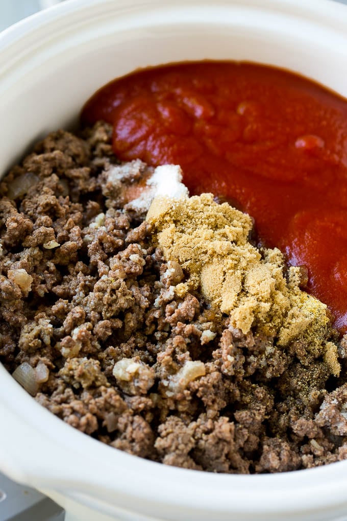 Ground beef, onions, tomato sauce, brown sugar and spices in a slow cooker.