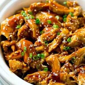 Slow cooker teriyaki chicken with shredded chicken breasts, homemade teriyaki sauce, sesame seeds and green onions.