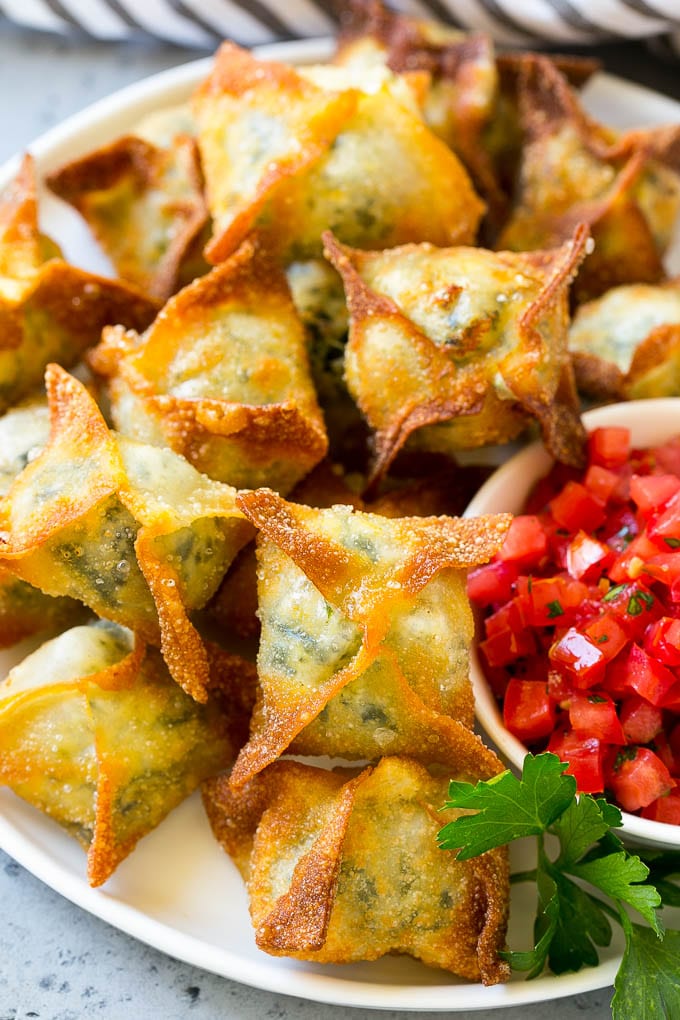 Spinach artichoke wontons on a serving plate.