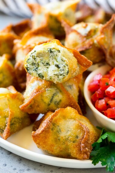 Spinach artichoke wontons with homemade spinach artichoke dip stuffed into wonton wrappers and fried.
