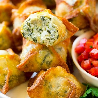 Spinach artichoke wontons with homemade spinach artichoke dip stuffed into wonton wrappers and fried.