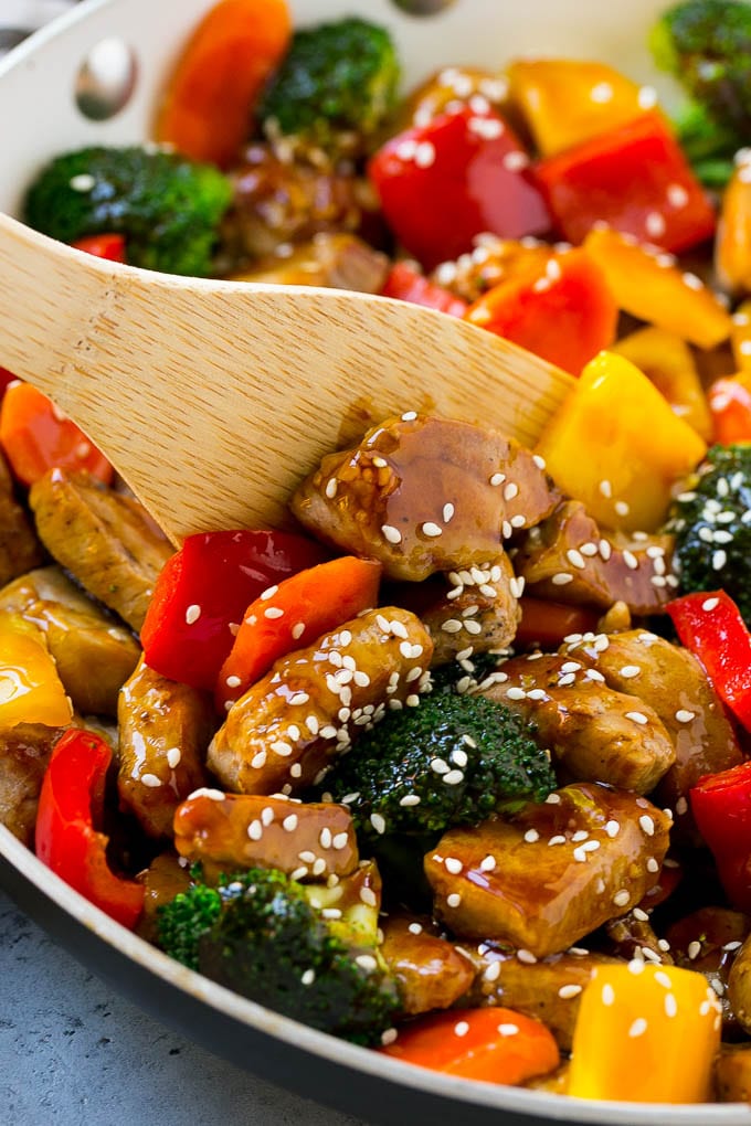 A pan of teriyaki pork stir fry with a spatula in it.