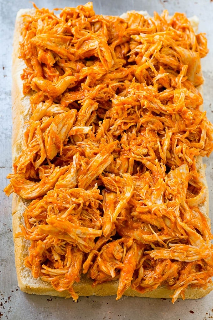 Shredded buffalo chicken spread over slider buns.