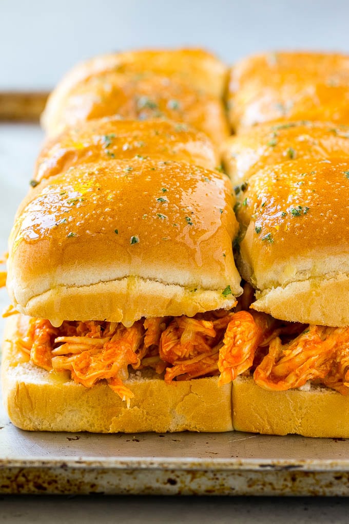 Buffalo chicken on slider buns brushed with garlic butter.