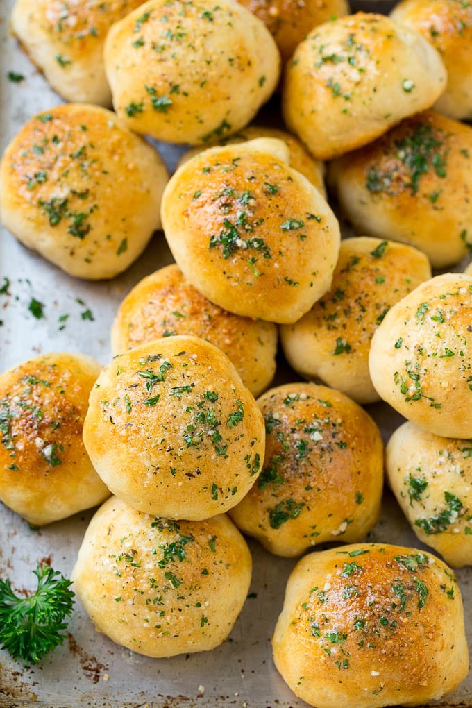 Baked cheese bombs topped with garlic butter on a sheet pan.