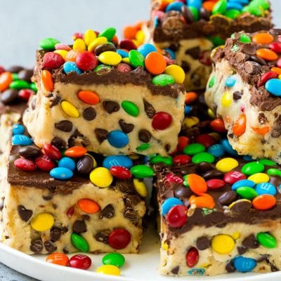 A plate of cookie dough bars studded with chocolate chips and M&M's.