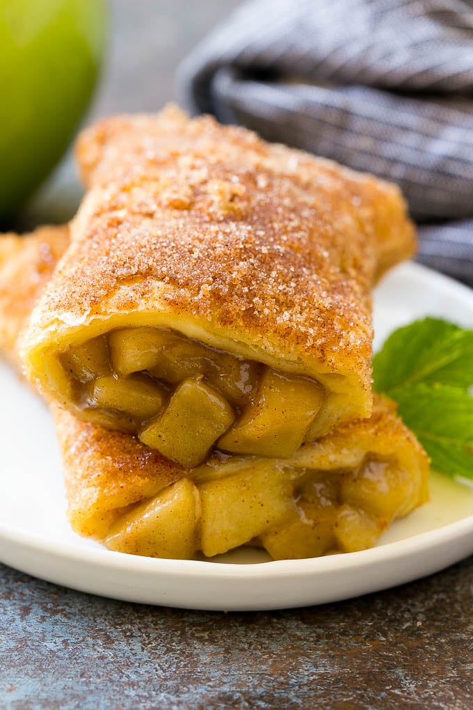 A cross section of a fried apple pie on a plate.