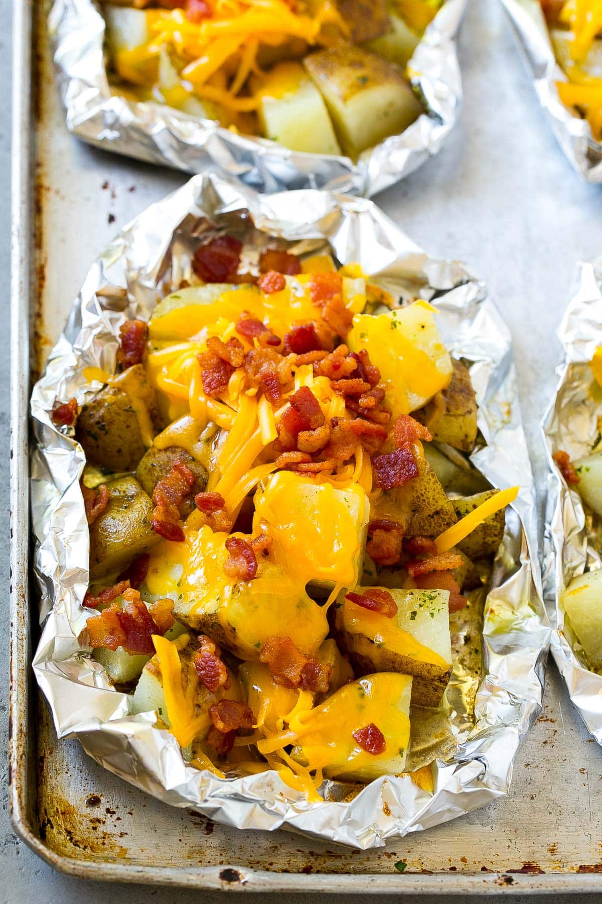 Cooked potatoes with shredded cheese and bacon on top.