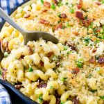 A skillet of jalapeno popper mac and cheese topped with crispy breadcrumbs, cilantro and bacon.