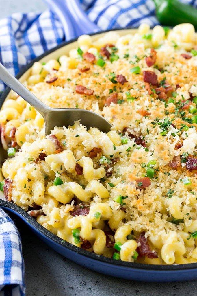 A skillet of jalapeno popper mac and cheese topped with crispy breadcrumbs, cilantro and bacon.
