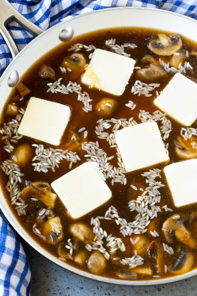 Rice with beef broth, onion soup and butter in a skillet.