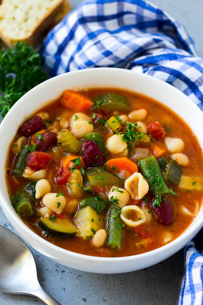 A bowl of Olive Garden Minestrone soup full of pasta, green beans, vegetables and broth.