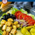 This Olive Garden salad recipe is a copycat of the restaurant favorite with lettuce, tomatoes, olives, onion and croutons, all tossed with a creamy Italian dressing.