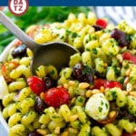 This pesto pasta salad is pasta with mozzarella cheese, olives, tomatoes and pine nuts, all tossed with fresh basil pesto.