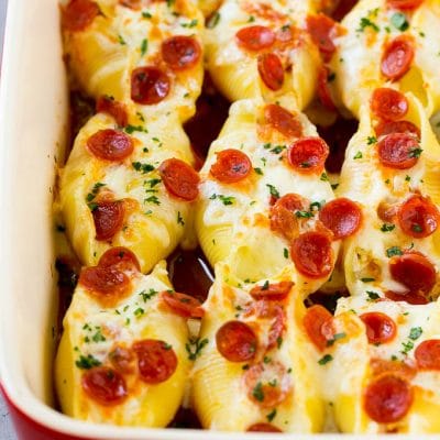 A baking dish full of pizza stuffed shells, topped with melted cheese and pepperoni.