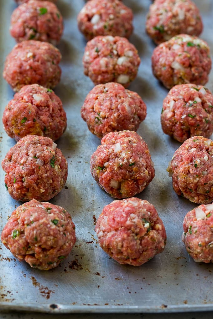 Raw meatballs on a baking sheet.