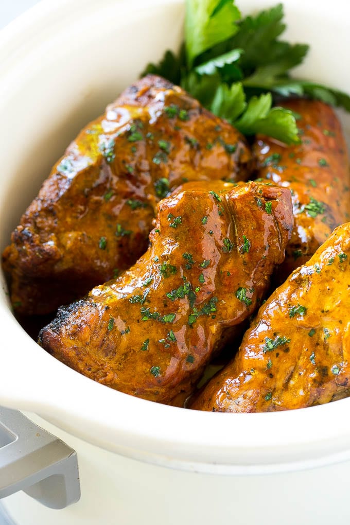 Slow cooker pork tenderloins coated with sauce, inside a crock pot.